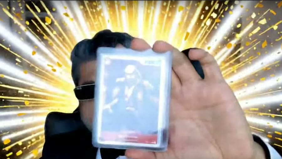A graded trading card held up to the webcam inside the Legendary Pull scene — the room is generated, the card is not